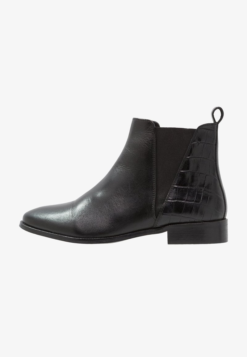 Bottine en cuir noir avec panneaux latéraux élastiques, bout pointu et accent texturé effet croco sur le talon. Surface lisse et polie.
