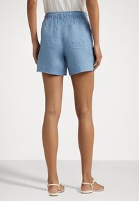 Modré lněné šortky s elastickým pasem, disponující dvěma zadními kapsami a pohodlným střihem. Hladký povrch, délka ke středu stehna.