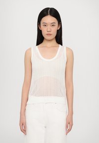 Balta bezpiedurkņu blūze no caurspīdīgas mežģīnes, ar ribotu apkakli un apakšmalu, rotāta ar smalku rakstu visā virsmai.