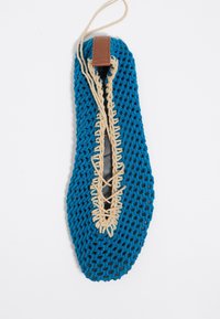 Blauw geweven schoen met een opvallend vetersysteem, tan leren accent bij de hiel en een lichte, flexibele constructie.