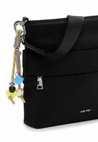 Czarna torba na ramię z tkaniny z górnym paskiem, ozdobiona kolorowymi zawieszkami i srebrnym zamkiem błyskawicznym z przodu. Wytłaczane logo po boku.