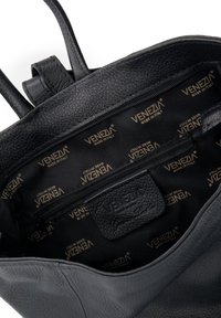 Sorte læderhåndtaske med synlig indvendig foring trykt "Venezia Made in Italy" og et indre lynlåsrum.