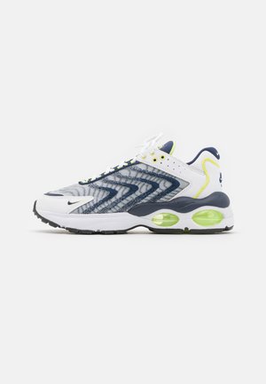 Nike sneakers med et design i hvid, navy og neongul. Tekstureret mesh-overdel, bølgeskema, synlig luftdæmpning i den grønne sål.