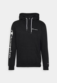 Haut à capuche noir en tissu doux, doté d'une poche avant, de cordons blancs et du logo "Champion" en blanc sur la poitrine et la manche.