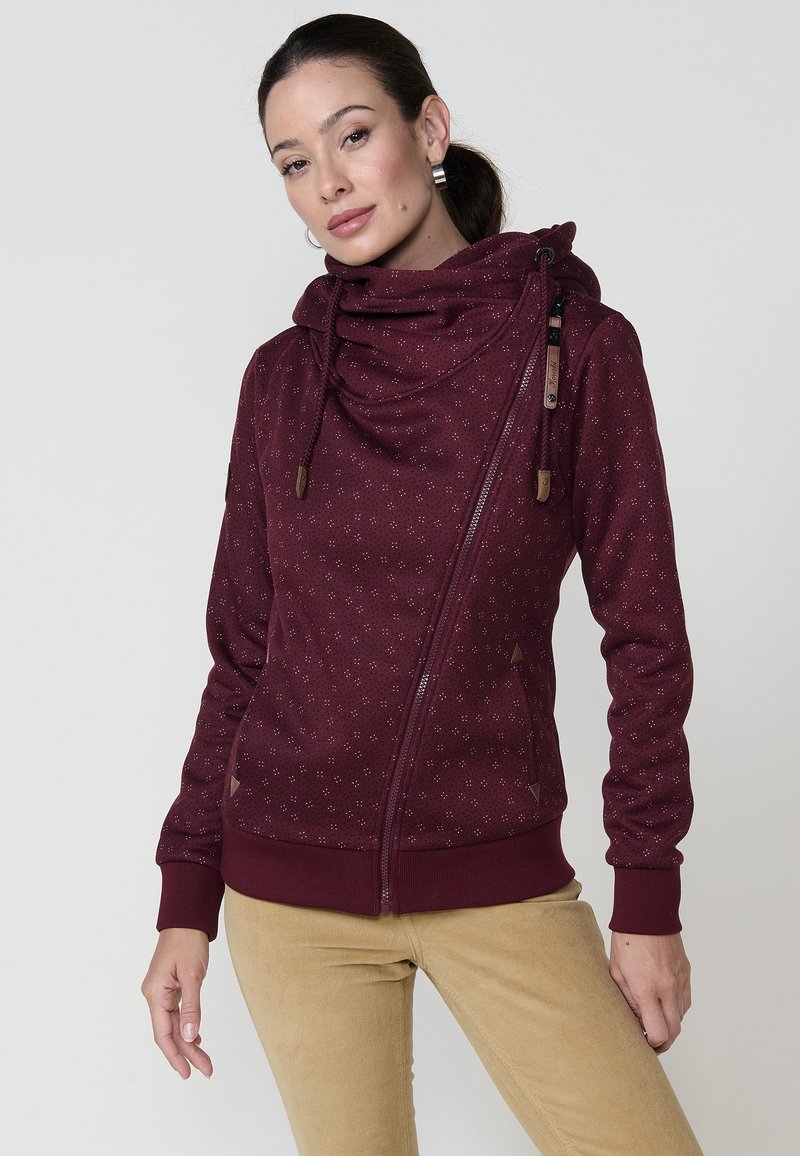 Bordo zip-up dukserica s kapuljačom, teksturirani materijal s malim točkicama, bočni zip, i kožne naglaske na vezicama.