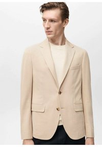 Blazer beige realizzato in tessuto testurizzato, con chiusura a un bottone, due tasche frontali e una vestibilità slim.