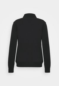 Sudadera negra con cuello alto, mangas largas y puños acanalados. El material parece suave y texturizado, con un diseño minimalista.