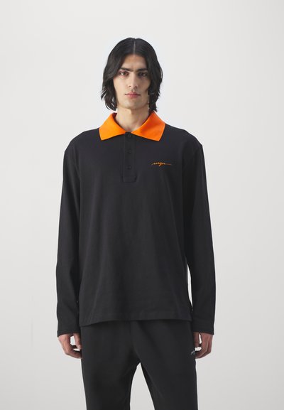 Svart langermet polo skjorte med oransje krage, med knappestolpe og brodert logo i oransje. Glatt bomullsstoff.