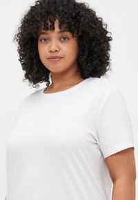 White short-sleeve t-shirt featuring a classic crew neck design. Made of soft, lightweight fabric with a smooth texture.