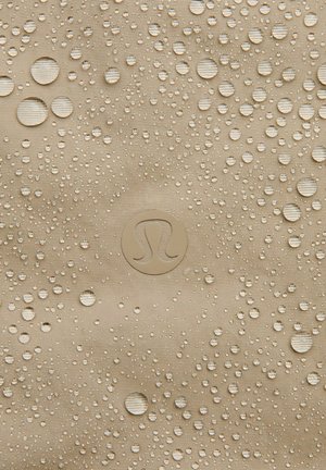 Beige, textured fabric with numerous water droplets; features a circular logo in the center. Material appears water-resistant.