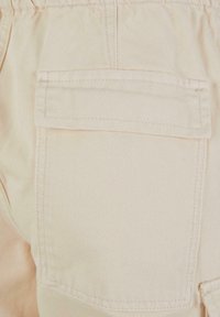 Beige denim shorts med baklomme med rett søm og myk tekstur; designet med elastisk midjebånd for komfort.