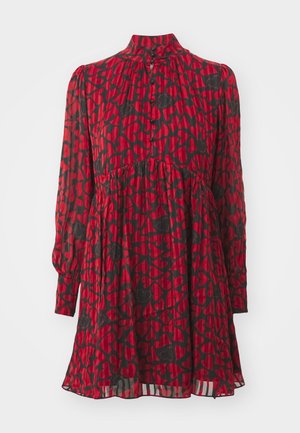 Piros ruha fekete szív mintával, magas nyakkivágással, hosszú ujjakkal, gombos záródással, összegyűrt derékvonallal és réteges textúrájú, lágyan omló szoknyával.