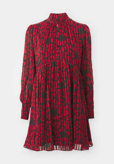 Piros ruha fekete szív mintával, magas nyakkivágással, hosszú ujjakkal, gombos záródással, összegyűrt derékvonallal és réteges textúrájú, lágyan omló szoknyával.