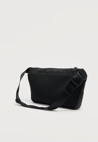 Μαύρο τσάντα ώμου με κομψό σχέδιο, κατασκευασμένη από υφασμάτινο ύφασμα με υφή και δίχτυ. Διαθέτει φερμουάρ και ρυθμιζόμενο ιμάντα.