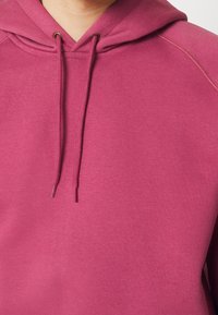 Fleece hoodie in magenta met een trekkoord kap, ribgebreide boorden en een soepele textuur. Bevat een kangoeroezak en stikseldetails.