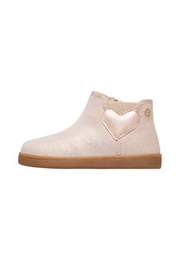Bottines à paillettes roses avec côtés élastiques, semelle beige, et un accent en forme de cœur métallique sur le côté extérieur, présentant une texture lisse et une forme arrondie.