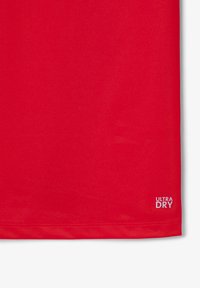 Röd idrottströja i mjukt, fukttransportande tyg. Har "ULTRA DRY"-logotypen i vitt nära nederkanten. Enkel design med korta ärmar.