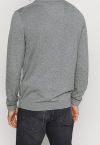 Grau gestrickter Pullover mit langen Ärmeln, gerippten Bündchen und Saum; hat eine glatte Textur und ein klassisches Rundhalsdesign.