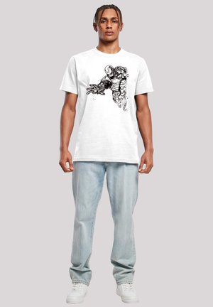 White cotton t-shirt featuring a black graphic design of a character on the front, paired with light blue jeans and white sneakers.