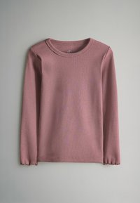 Kohvri väljavenitatud varrukatega tipp pehmest mauve'ist, ringkraega ja kulunud äärega, valmistatud kerge puuvillase segu kangast.