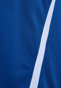 Blått stoff med en vertikal hvit stripe, som viser tekstur og vev av materialet i nærbilde.