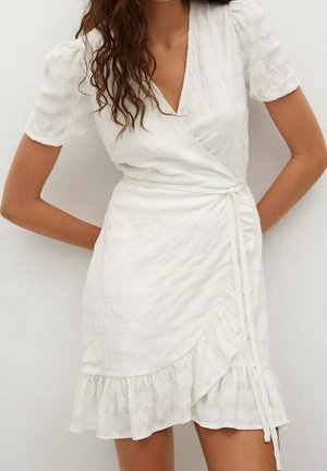 Robe blanche à manches courtes bouffantes, en tissu texturé, avec un ourlet en volants et un détail de taille à nouer.