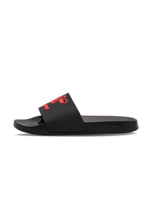 Sandale slide noire avec une large bride comportant un logo d'abeille stylisée rouge et le nom de la marque, semelle plate, vue de côté.