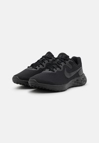 Scarpe sportive nere con tomaia in rete, accentuazioni lisce e suole texturizzate. Presentano un logo swoosh prominente e chiusura con lacci.