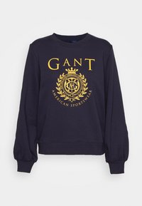 Felpa navy con logo giallo che presenta una corona e una lauro, con polsini a coste e una vestibilità comoda. Realizzata in un materiale morbido.