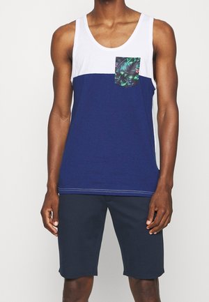 Navy blue tank top featuring white upper section, a floral-patterned pocket, and light stitching details. Paired with dark shorts.