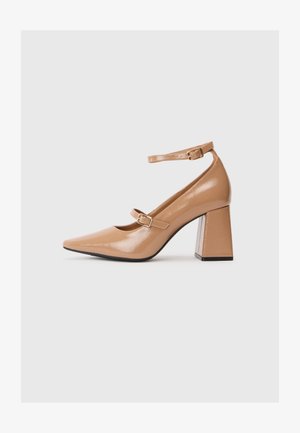 Beżowe lakierowane szpilki z wydłużonym noskiem, paskiem wokół kostki i masywnym kwadratowym obcasem. Gładka tekstura z błyszczącym wykończeniem.