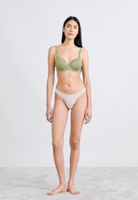 Σουτιέν ελιάς με περίτεχνη δαντέλα και ρυθμιζόμενους ιμάντες, σετ με ανοιχτό μπεζ εσώρουχο. Λείο ύφασμα με εφαρμοστή κοπή.