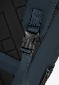 Marine stoffen schouderriem met een gestructureerd zwart bevestigingspunt en kunststof gespsluiting. Heeft een geometrisch patroon op het oppervlak eronder.