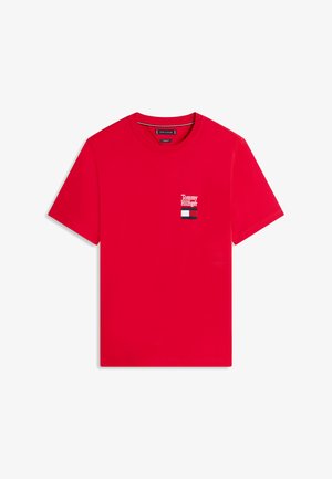 Punane lühikeste varrukatega ümarkaelusega t-särk, millel on vasakul rinnal väike valge "Tommy Hilfiger" tekst ja punane, valge ning sinine logo.