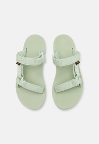 Sandalias verde claro con correas y suelas texturizadas. Cuenta con correas ajustables para un mejor ajuste. El material parece ligero y flexible.
