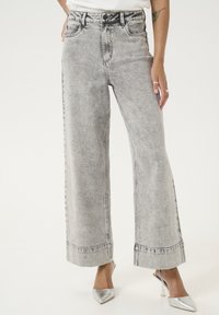 Bredde grå denim jeans med en tekstureret finish, der har forlommer, en knaplukning og en lige kant.