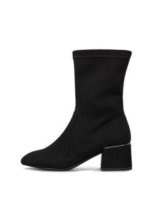 Botín negro de mujer hasta la mitad de la pantorrilla con punta afilada, tacón cuadrado y textura suave, mostrado en perfil lateral contra un fondo blanco.