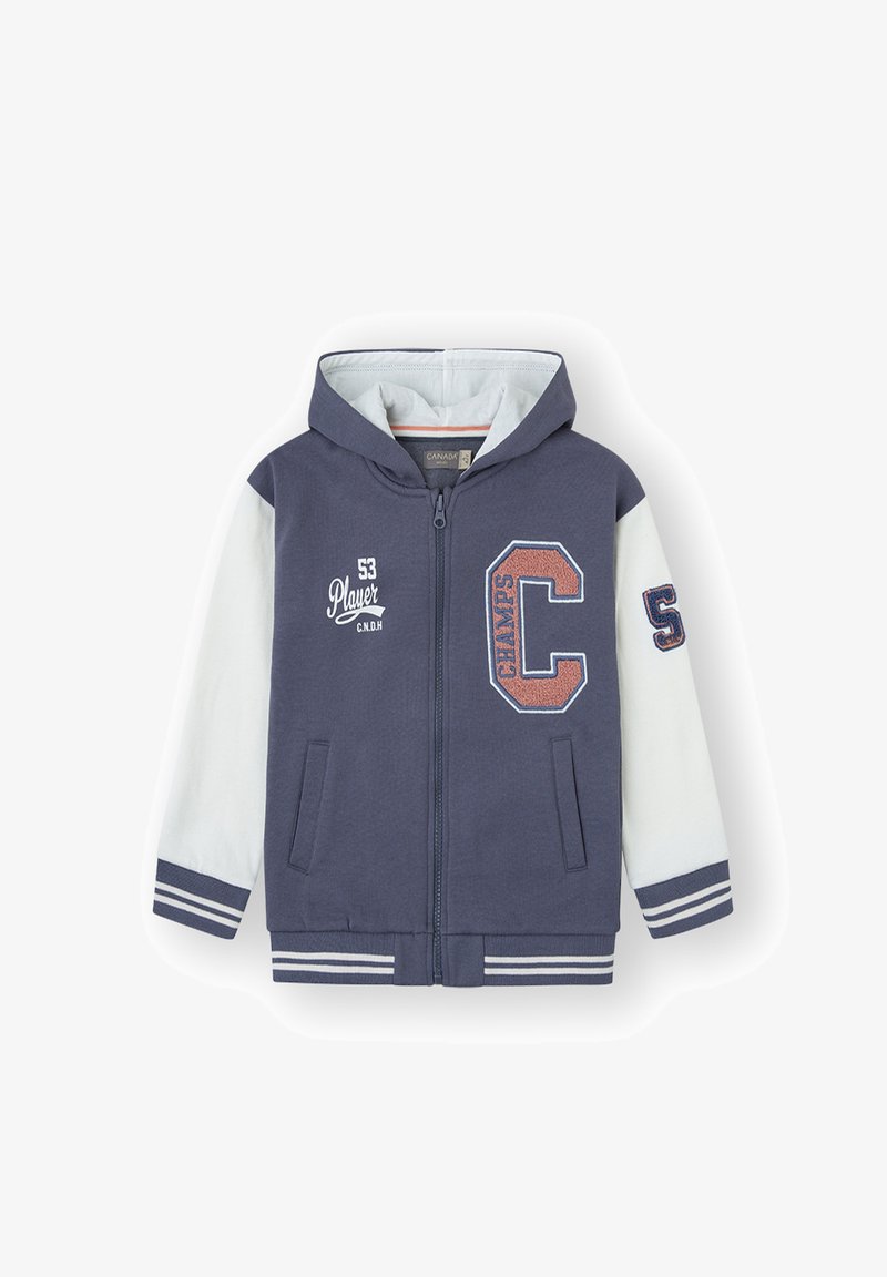Chaqueta con capucha y cremallera de cuerpo azul marino y mangas blancas. Presenta letras bordadas, bolsillos laterales y puños y dobladillo de canalé a rayas.