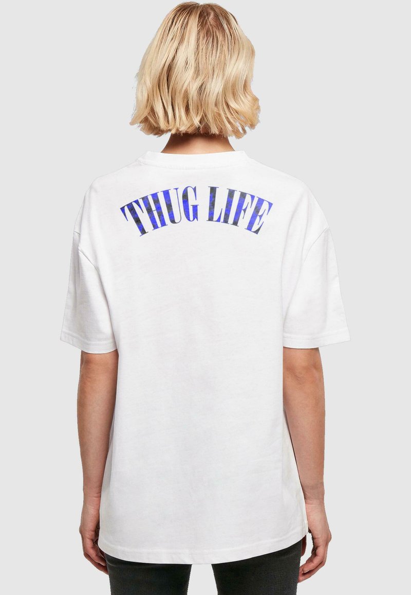 Tricou din bumbac alb, cu textul albastru "THUG LIFE" impriminat în design arcuit pe spate. Croială oversized, cu mâneci scurte.