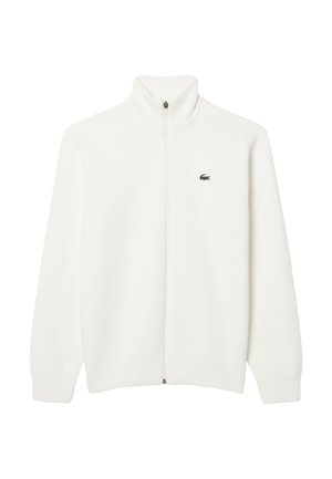 Maglione bianco a coste con zip e colletto alto, dotato di un piccolo logo verde sull'area del petto sinistro. Tessuto morbido, maniche lunghe e vestibilità dritta.