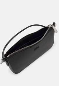 Pochette noire texturée avec une fermeture éclair, au design épuré et à une courte poignée ; comprend un accent en métal argenté et des compartiments intérieurs.