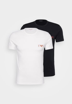 Dos camisetas de manga corta; una blanca con un logo rojo, la otra negra con un logo a juego. Ambas tienen un cuello redondo clásico y una textura suave.