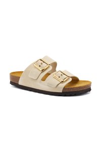 Sandali in suede beige chiaro con due cinturini regolabili, fibbie in tono dorato e una suola in sughero marrone con battistrada in gomma texturizzata.