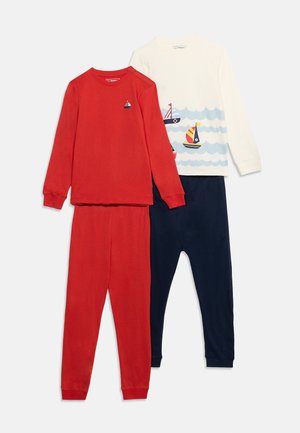 Δύο σετ παιδικές πυτζάμες με μακριά μανίκια: ένα κόκκινο με ένα μικρό ιστιοφόρο, ένα λευκό με ιστιοφόρα και κύματα σε συνδυασμό με μπλε σκούρο παντελόνι.