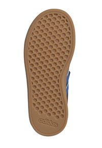 Suela de zapatilla azul con un patrón de panal, con un material de goma marrón. Logo de "adidas" en relieve cerca del borde inferior.