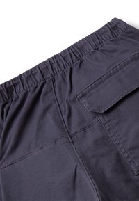 Ciemnoszare spodnie z elastycznym paskiem w talii, z kieszonką klapową po prawej stronie z tyłu oraz widocznymi detalami szycia.