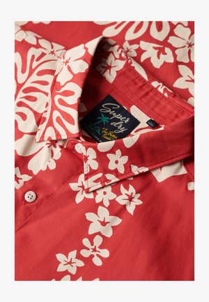 Czerwona bawełniana koszula z białymi kwiatowymi wzorami, z kołnierzykiem zapinanym na guziki oraz metką "Superdry". Miękka w dotyku z gładkim wykończeniem.