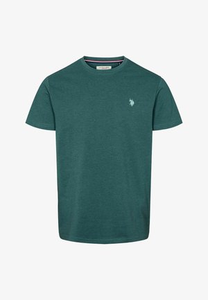 Zöld pamut póló kerek nyakkivágással és rövid ujjakkal; a mellkason egy apró hímzett logó található. Simá szövet, laza szabású.