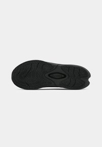 Sola preta de sapato com padrão de textura e marca "Clarks" ao centro, exibida sobre um fundo branco.