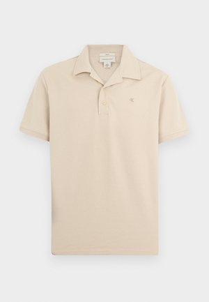 Bézs rövid ujjú galléros póló kétgombos patenttal, gallérral és a bal oldali mellrészen kis hímzett "ck" logóval.